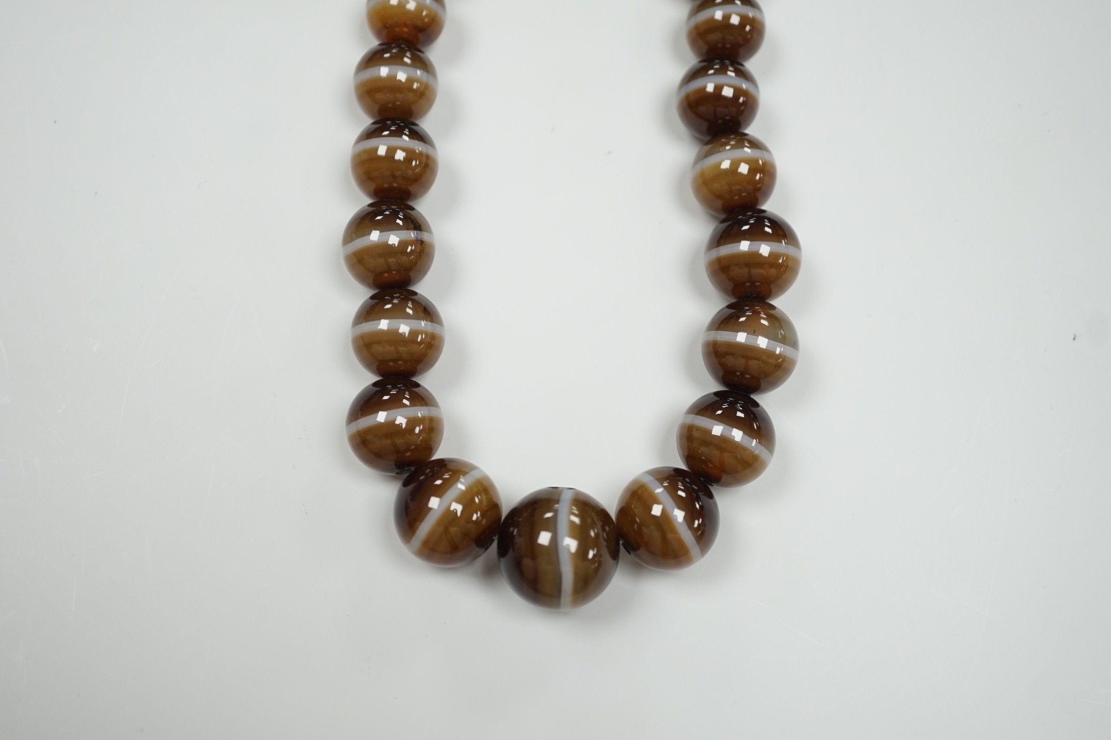 A single strand graduated banded agate circular bead necklace with yellow metal clasp, 46cm.